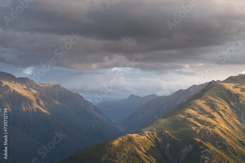 Scenic Mountain Sunset: Stunning Light Bathing Majestic Peaks Amidst Dramatic Clouds