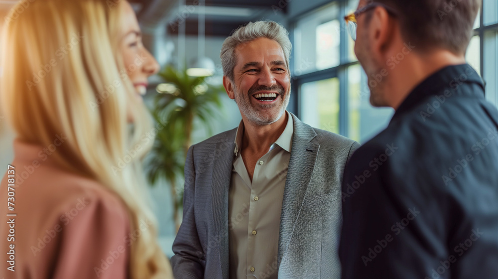 Happy multi-generational team engaging in a light-hearted conversation at work. Casual business meeting with a cheerful mature professional and young adults. Happy multi-generational team engaging in a light-hearted conversation at work. Casual business meeting with a cheerful mature professional and young adults.
