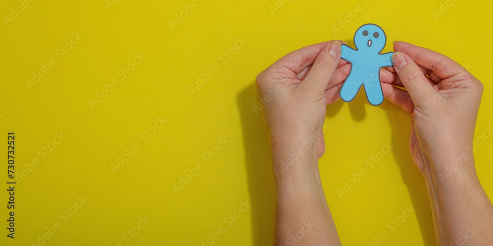 World mental health day. Male hands holding paper men figures with different emotions World mental health day. Male hands holding paper men figures with different emotions