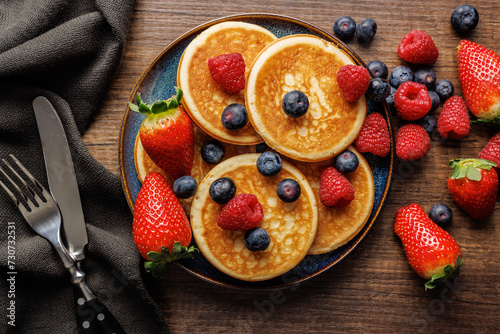 Homemade classic american pancakes with blueberries, raspberries and strawberries. Top view. photo