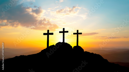 Silhouette of three crosses on a rock with sunset in the background. Easter concept. photo