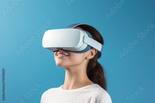 Woman wearing a virtual reality headset against a blue background. Perfect for technology and gaming concepts © Fotograf
