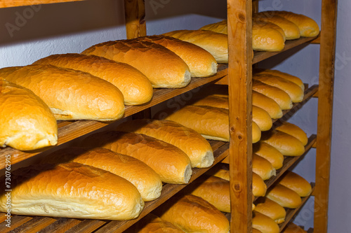 Obraz na płótnie Fresh bread resting on shelves before transportation to the shops. w salonie