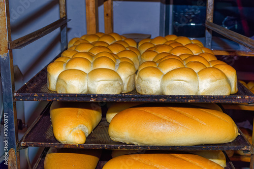 Obraz na płótnie Fresh bread resting on shelves before transportation to the shops. w salonie