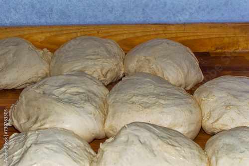 Obraz na płótnie Fresh bread dough resting at wooden table in bakery. w salonie
