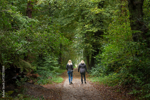 Walking in the forest. Two women going for a stroll at Roden Drente Mensinge Estate Netherlands. Forest path.