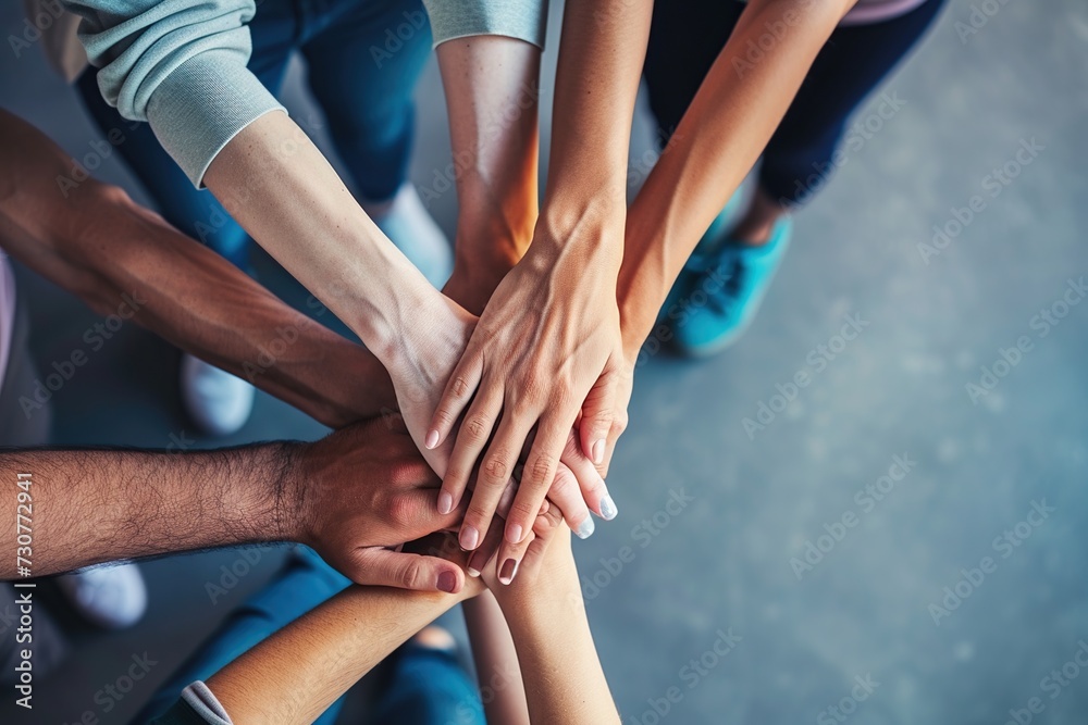 A top view of a group people stacking their hands together, symbolizing unity, teamwork, and mutual support with copy space.