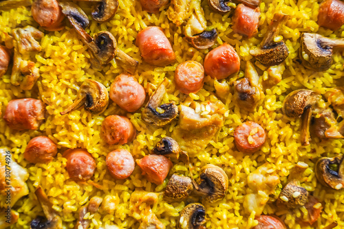 Close-up of paella with vibrant yellow rice and mixed ingredients.
