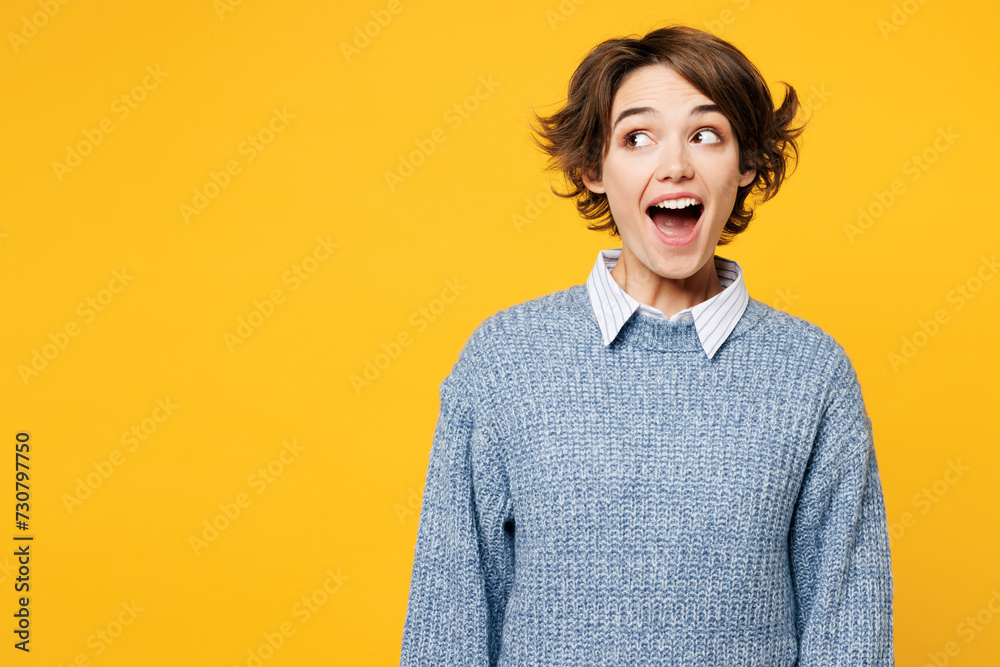 Young surprised shocked cool fun excited woman she wearing grey knitted sweater shirt casual clothes look aside on area mock up isolated on plain yellow background studio portrait. Lifestyle concept. - obrazy, fototapety, plakaty 
