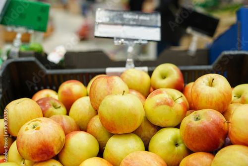 Red and yellow apples in the boxes in big grocery store. ripe apples