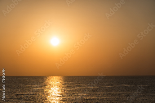 very bright white sun with reflection in the water during sunrise © thomaseder