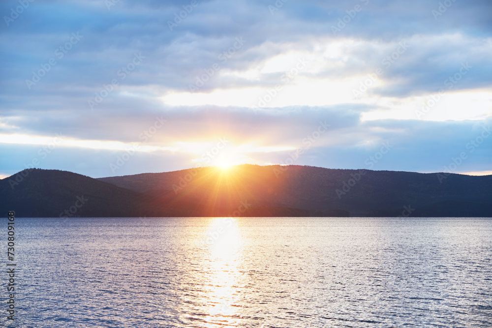 Scenic sunset on tha lake with mountains