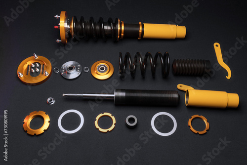 suspension tuning, coilovers, shock absorbers and front springs in yellow and gold colors for a sports drift car on a dark background	 photo