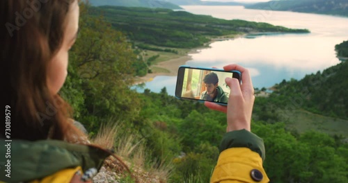 Woman, video call and pointing at nature or view, internet connection and communication on phone. Couple, blowing kiss and virtual conversation on outdoor adventure, love and bonding on mobile app