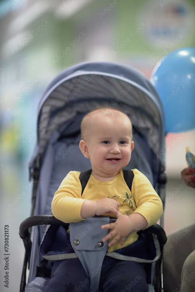 a one-year-old child, a boy, eats on the road, has a snack on the way in a stroller a one-year-old child, a boy, eats on the road, has a snack on the way in a stroller