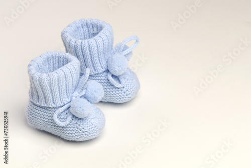 baby booties, for newborns, the first shoes with delicate feet on a light background