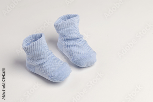 baby socks, for newborns, the first shoes with delicate feet on a light background