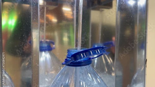 Drinking water bottling process. A five-liter plastic bottle in a drinking water vending machine. Close-up. The bottle is filled with drinking water. Water for drinking and cooking is healthy. photo