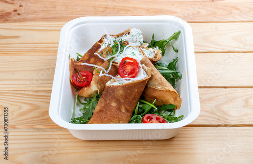 Caneloni with ricotta cheese and spinach. Takeaway food. On a wooden background. photo