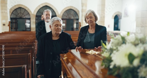 Senior women, coffin and funeral in church for memory, support and condolences with religion with family. Community, friends and together for death, loss and service with empathy, faith and casket photo
