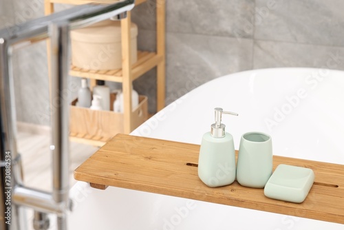 Set of bath accessories on tub in bathroom
