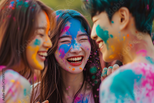 Korean girls and a guy with blue powder on their faces and clothes at the Holi festival of colors.