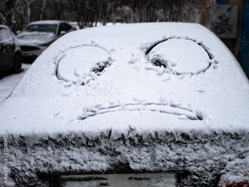 snowy car with drawn eyes. the problem of snowy roads