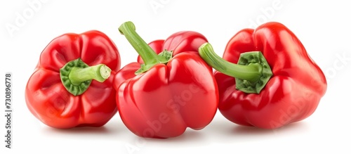 Three red peppers with green stems, a natural food and vegetable, showcased on a white background.