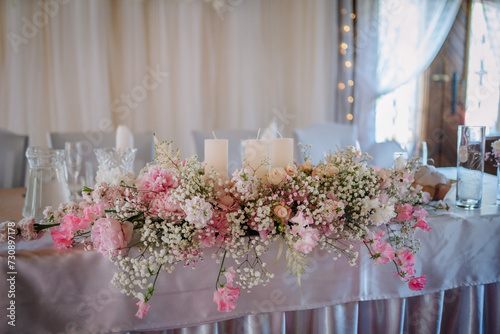 Valmiera  Latvia - July 7  2023 - Elegant wedding table with a pink and white floral arrangement and candles.