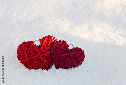 Happy valentines day background with two red hearts on white snow .
