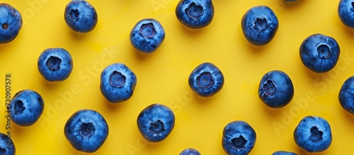 Isolated blueberries on a yellow background, a healthy summer fruit.
