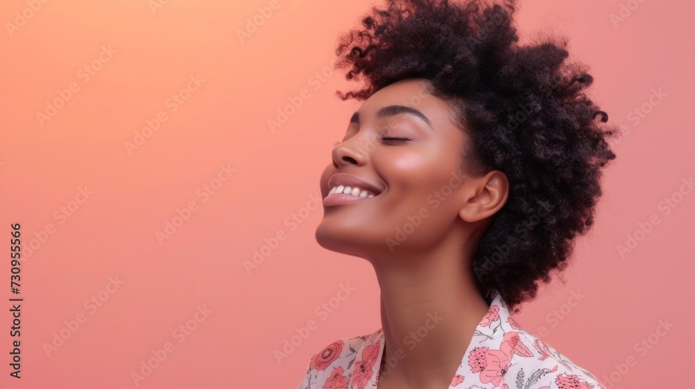 A joyful woman with a radiant smile closed eyes and curly hair set against a soft pink background exuding a sense of happiness and contentment. A joyful woman with a radiant smile closed eyes and curly hair set against a soft pink background exuding a sense of happiness and contentment.