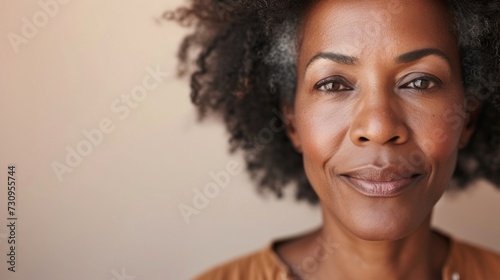 A close-up portrait of a smiling woman with curly hair showcasing her warm complexion and gentle expression.