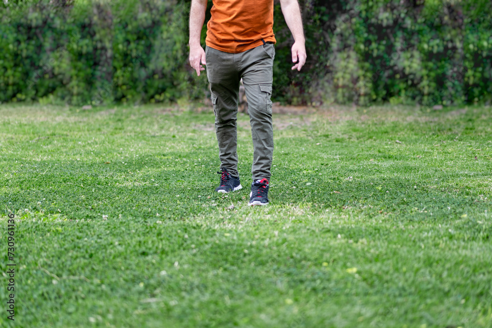 Man legs walking to the camera over green grass.. Man legs walking to the camera over green grass..