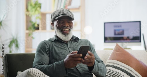 Phone, chat and senior man on sofa with funny meme, gif or social media at home. Smartphone, streaming or old African person in a living room for retirement entertainment with online dating app photo