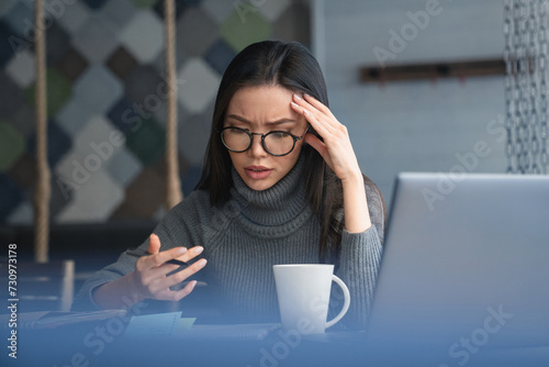 Stressful woman entrepreneur checking work process sitting at the office. Problems at workplace, deadline, workload, overworked exhausted freelancer employee photo