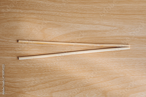 1 pair of chopsticks with wooden background.