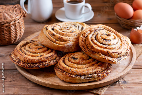 Homemade sweet twisted buns with poppy seeds on table
