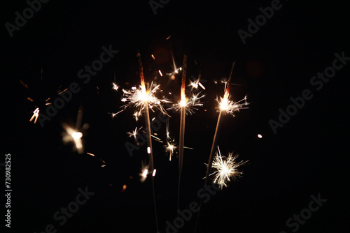 Fireworks spark at high speed with a black background, and Burning sparklers with many beautiful sparks on a black background. Concept of New Year or birthday celebration