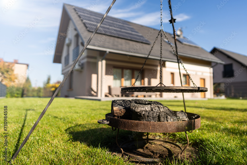 summer party in the garden - bonfire/barbecue in a new detached house with photovoltaics