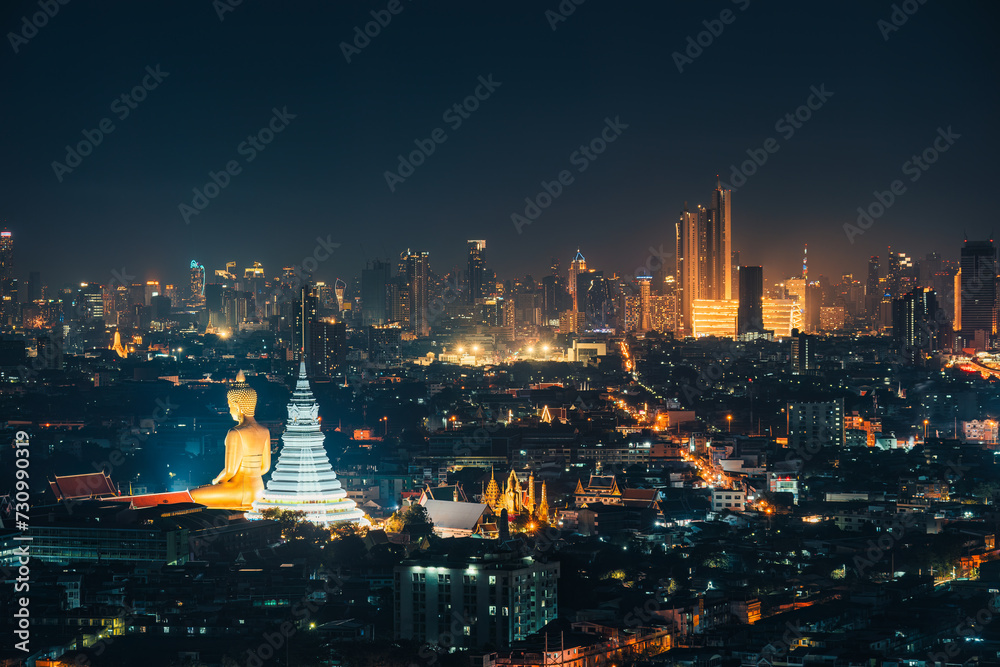 Obraz premium Cityscape of Bangkok night scene with building exterior, buddha in temple and department store glowing in downtown