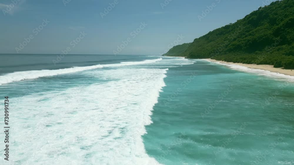 Aerial view along the sandy shore and undulating ocean on a sunny day. Slow motion. Aerial view along the sandy shore and undulating ocean on a sunny day. Slow motion.