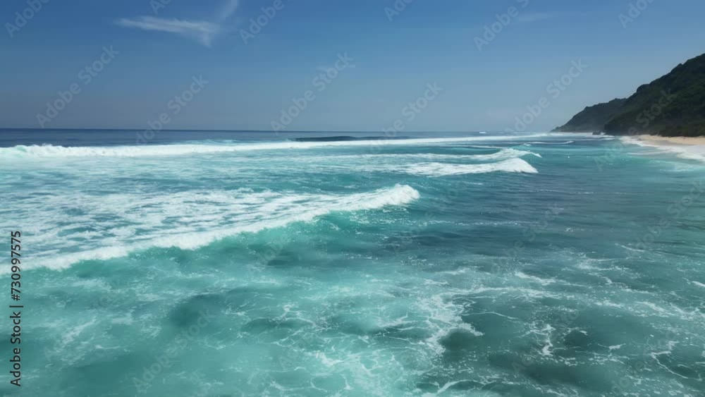 Aerial low flying over the waves of the ocean on a sunny day. Aerial low flying over the waves of the ocean on a sunny day.