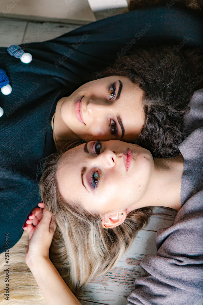 Indoor fashion beautiful ladies together lifestyle. Pretty girl friends portrait in sweaters.