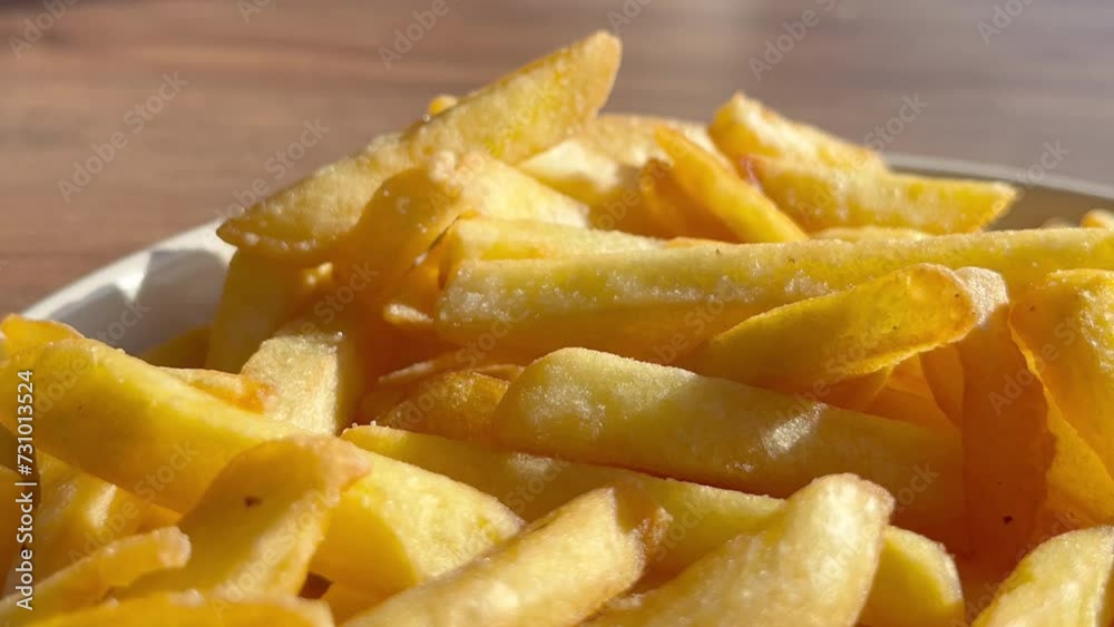 Close up view of hand taking hot crispy French fries from plate in cafe. Closeup shot of French fry with the blurry background of modern fast food cafeteria. High quality 4k footage Close up view of hand taking hot crispy French fries from plate in cafe. Closeup shot of French fry with the blurry background of modern fast food cafeteria. High quality 4k footage