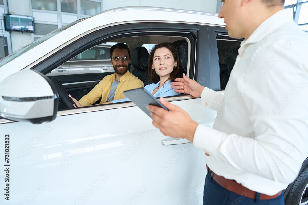Manager advises a couple before test drive of new car Manager advises a couple before test drive of new car