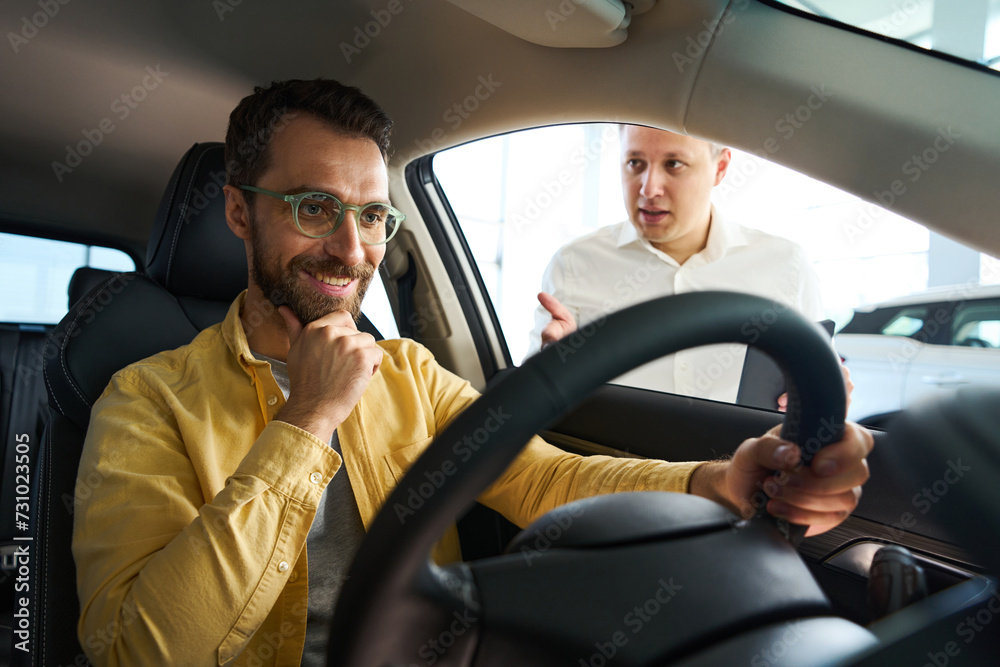 Satisfied customer in car is studying functionality of popular model Satisfied customer in car is studying functionality of popular model