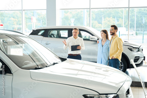 Customer service manager presents a popular car model to customers