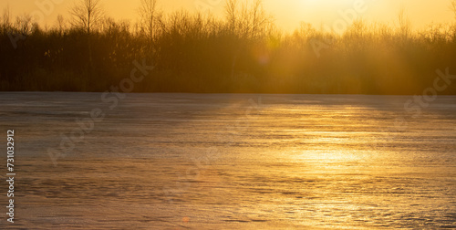 North-eastern European river after frosty winter. Porous ice began to melt, river is swollen, state of ice week before ice break (ice-boom). Aurora, sunrise colors on a spring moning photo