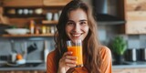 Happy young woman drinking carrot juice
